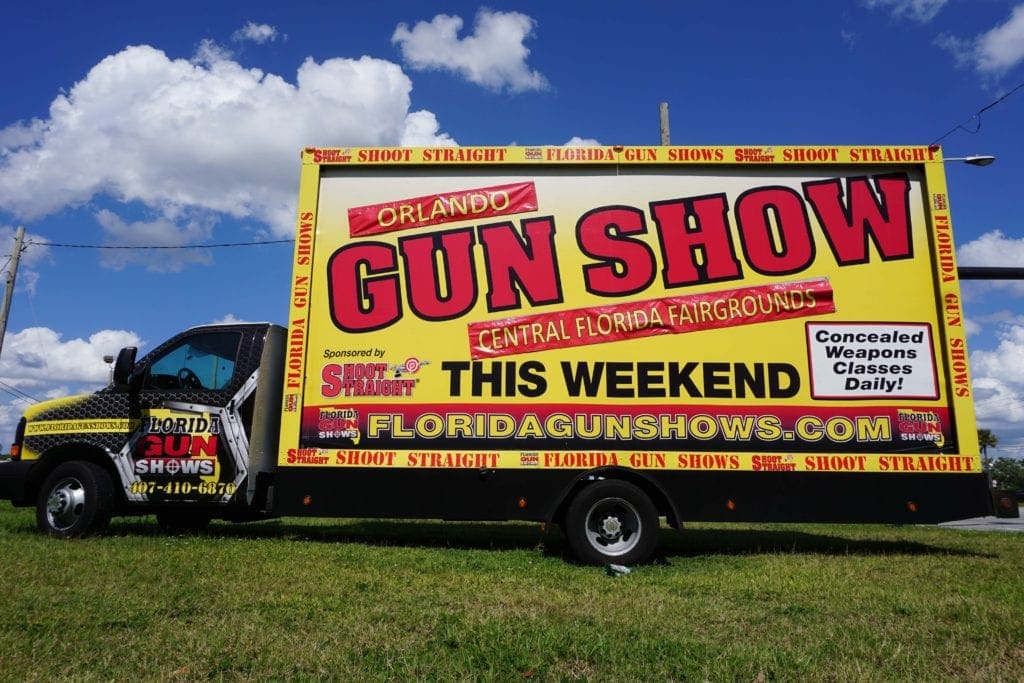 Truck boasting Orlando gun show billboard. 