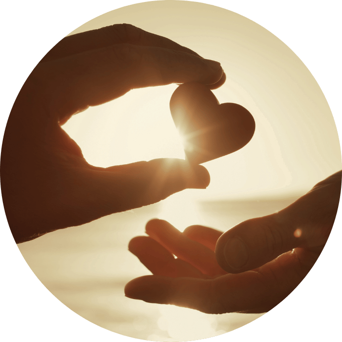 hand passing a heart shape cut-out to other hand